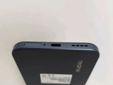 the back of a black cell phone sitting on top of a white table