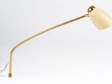 a gold desk lamp with a white shade on a white background