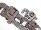 two adjustable wrenes sitting on top of each other