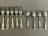 a lot of spoons and forks lined up on a table