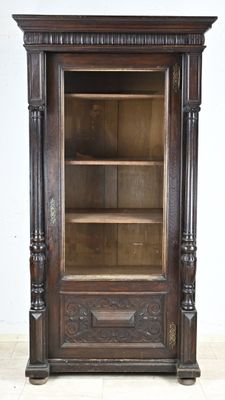 an old wooden cabinet with a glass door on it