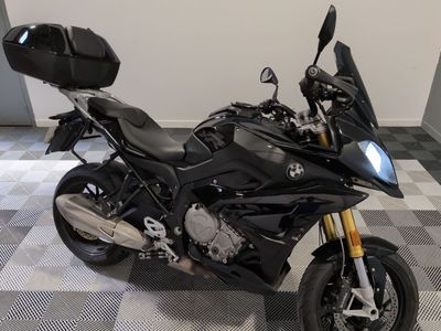 une moto noire garée dans une pièce au sol carrelé