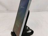 a close up of a cell phone on a stand on a white surface