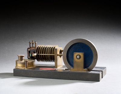 une petite maquette de machine à vapeur posée sur un socle