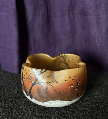 a bowl with a painting on it sitting on a table