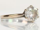 a close up of a diamond ring on a white surface
