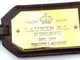 a brown leather luggage tag with a gold plate on it