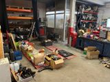 a garage with a lot of clutter and tools on the floor