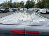 many cars parked in a parking lot with a sky background
