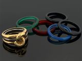 quatre anneaux de couleurs différentes posés sur une surface noire