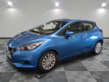 une voiture bleue est garée dans une pièce au sol à carreaux