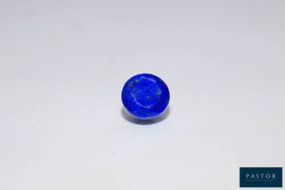a close up of a blue stone on a white surface