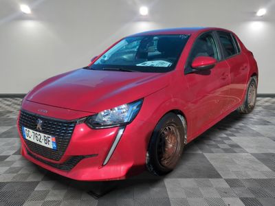 une voiture rouge est garée dans une pièce au sol en damier
