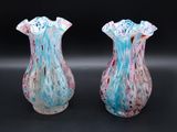 pair of blue and pink glass vases on a black surface