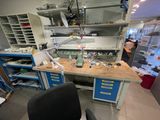 une photo d'un établi dans un laboratoire, sur lequel s'entassent de nombreux objets