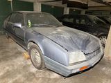a car that is sitting in a garage with other cars in the background