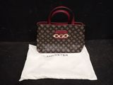 un sac à main marron et rouge posé sur un sac blanc