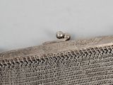 an old silver purse with a chain around the clasp