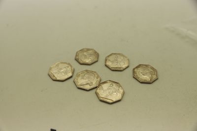 plusieurs pièces d'or posées sur une surface blanche