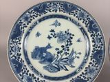 pair of blue and white plates with flowers and birds on them