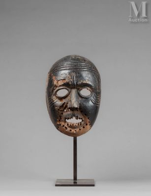 a wooden mask on a stand with a gray background