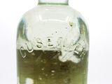 a bottle with a liquid inside of it sitting on a table
