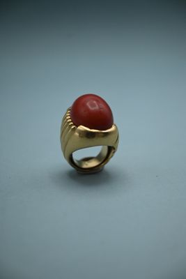 an image of a gold ring with a red stone in it