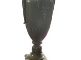 a vase on a stand with a plaque on it