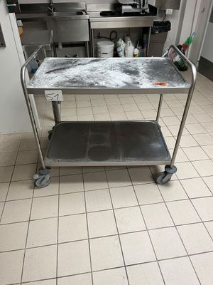 a kitchen with a metal cart with a lot of stuff on it