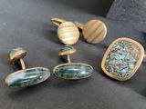 several different types of cufflinks are displayed on a table