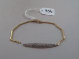 bracelet plaqué or orné d'une barre sertie de diamants et muni d'une étiquette de prix sur le côté