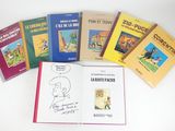 several children ' s books are lined up on a white surface