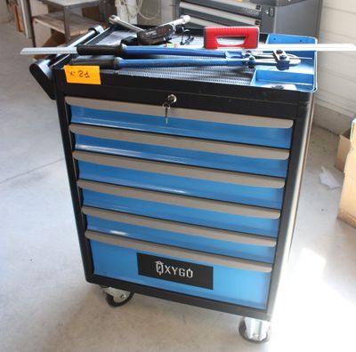 un chariot à outils bleu contenant des outils, dans un garage