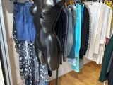 a mannequin on a stand in a clothing store