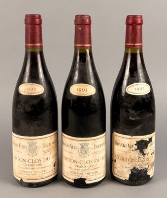trois bouteilles de vin sont alignées sur une surface grise