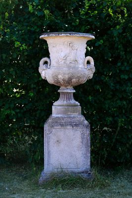 a large white urn sitting in the middle of the grass