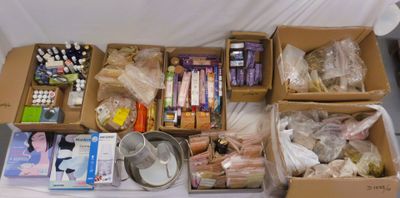 Plusieurs cartons contenant des objets divers sont posés sur une table.