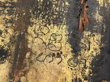 a rusted surface with graffiti on it and a fire hydrant in the background
