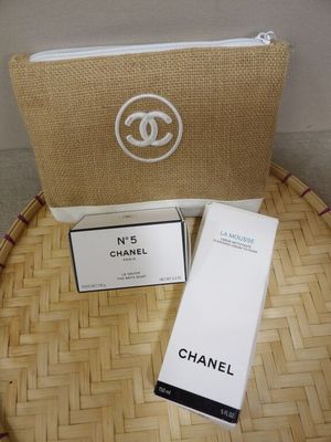 chanel makeup bag and lotion box on a bamboo tray