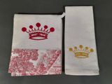 Deux serviettes ornées de couronnes sont posées sur une table