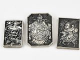 three silver metal objects sitting next to each other on a white surface