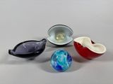 four different colored glass bowls sitting next to each other on a table