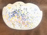 un bol blanc orné de fleurs, posé sur une surface marron