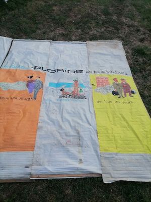 une couverture avec des images de personnes, posée sur l'herbe