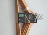 wooden clothes hangers on a white surface with a black tag