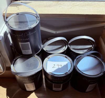 plusieurs pots de peinture posés sur un rebord de fenêtre, à côté d'un autre rebord de fenêtre
