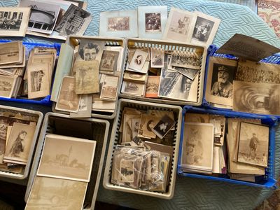 a lot of old photos in a box on the bed