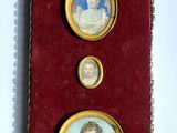 deux portraits miniatures représentant une femme et un homme, dans un écrin rouge