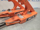pair of orange hand tools sitting on top of a metal table