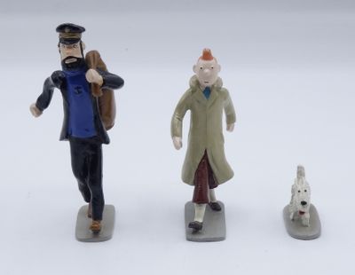 three figurines of a man and a woman and a dog
